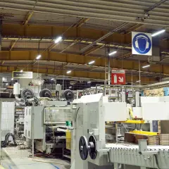 Jasne, oto opis:

Nowoczesne oświetlenie hali magazynowej zapewnia widoczność maszyn produkcyjnych i stosów kartonów.