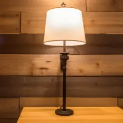 Stojąca lampa z abażurem na drewnianym stoliku, tło z desek. Potrzebna naprawa lamp stojących?