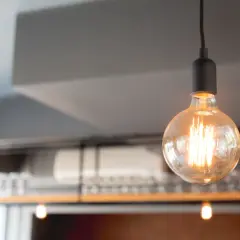 Dwie żarówki Edisona wiszą pod sufitem, tworząc ciepłe światło. Ich styl retro idealnie pasuje do wnętrza, gdzie liczą się odpowiednie lumeny na m2.