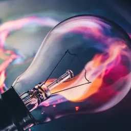 Żarówka z kolorowym, abstrakcyjnym tłem. Zastanawiasz się, ile to wat, gdy masz 1200 lumenów?
