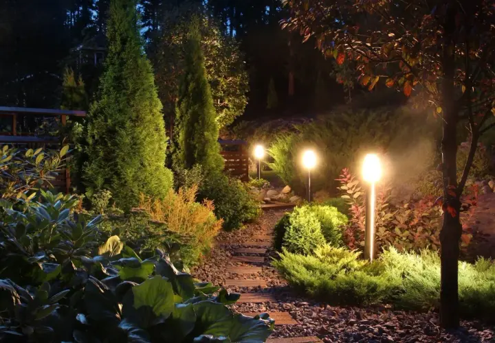 Pięknie oświetlony ogród nocą. Lampki solarne, które same się ładują, tworzą magiczną atmosferę.