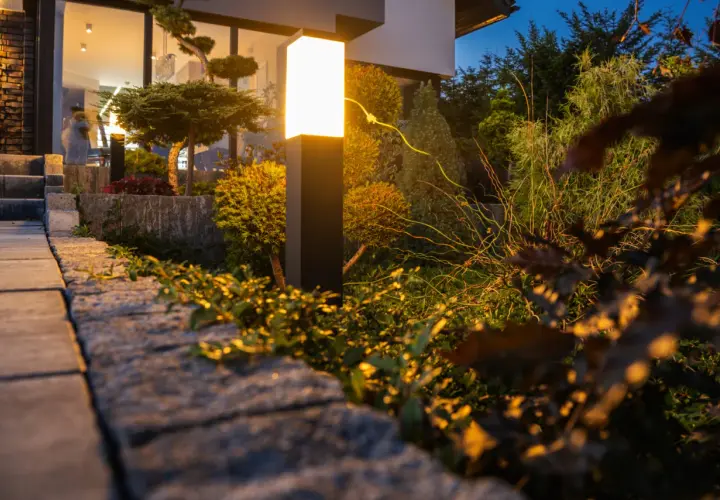 Nowoczesna lampa oświetla ogród, tworząc magiczną atmosferę. Zobacz, jak oświetlić ogród, by był piękny nocą.