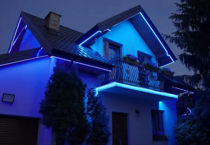 Elegancki dom nocą, podkreślony niebieskimi listwami LED zewnętrznymi, które oplatają dach i balkon, tworząc magiczną atmosferę.