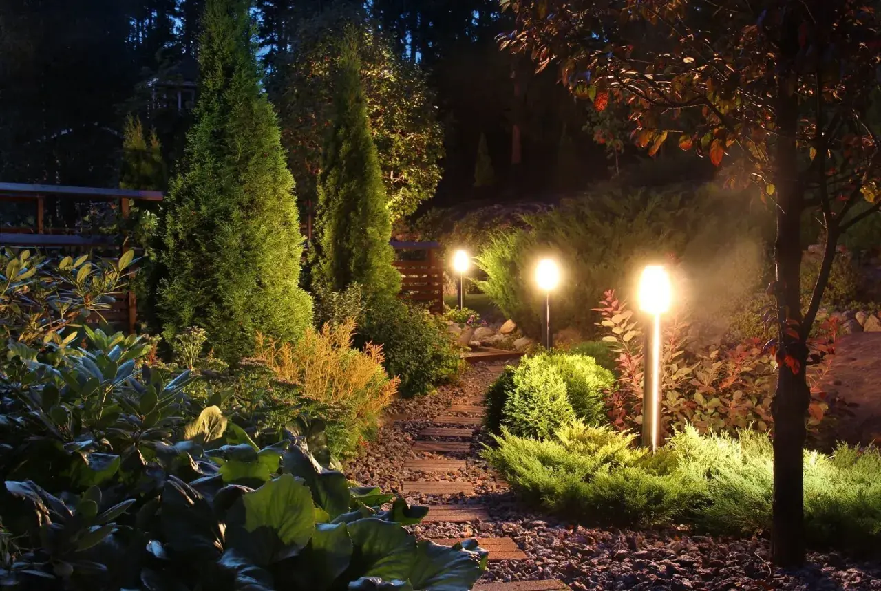 Pięknie oświetlony ogród nocą. Lampki solarne, które same się ładują, tworzą magiczną atmosferę.