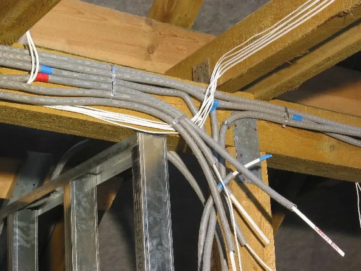Instalacja elektryczna pod sufitem, przygotowana do dodania punktu świetlnego. Widać peszle i przewody.